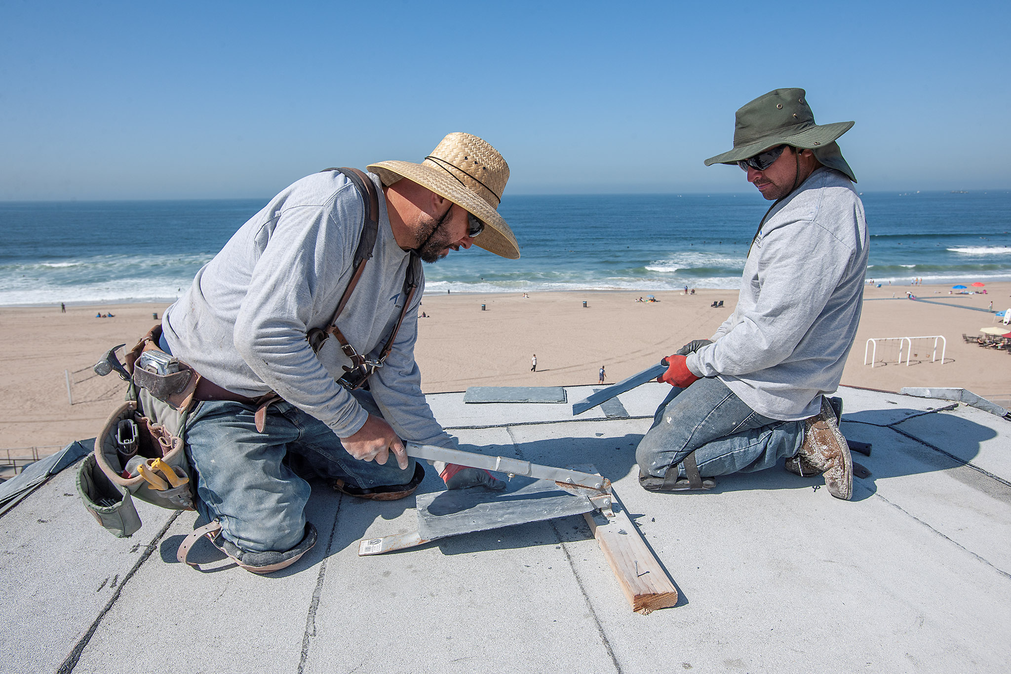 Roofers install coppper flashing on the Strand, Manhattan Beach, California