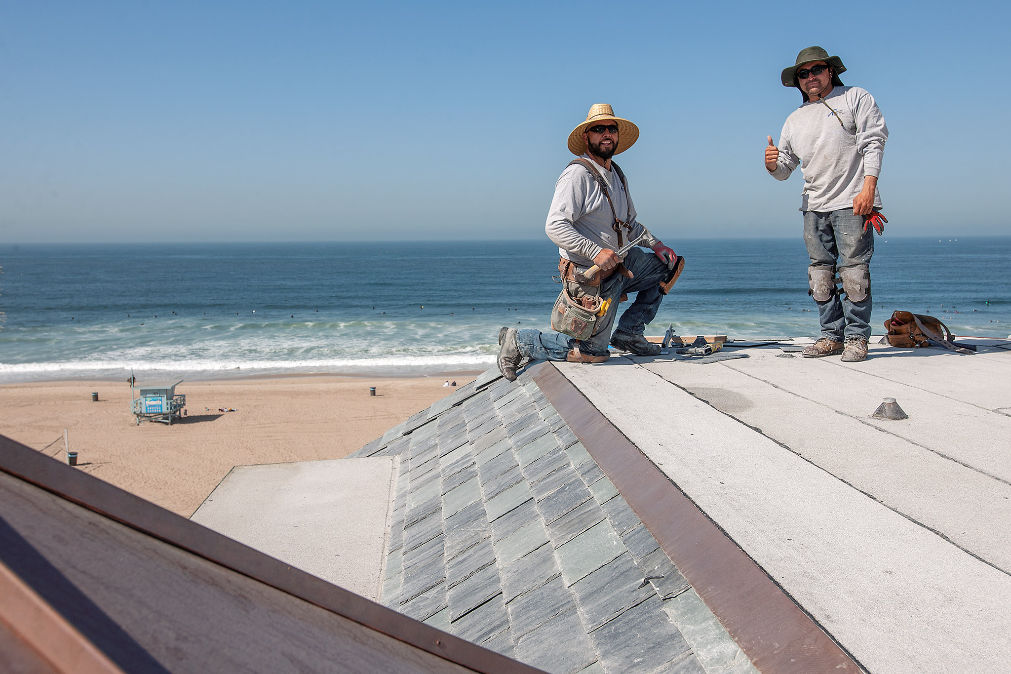Workers on the flat roof section, Manhattan Beach, California