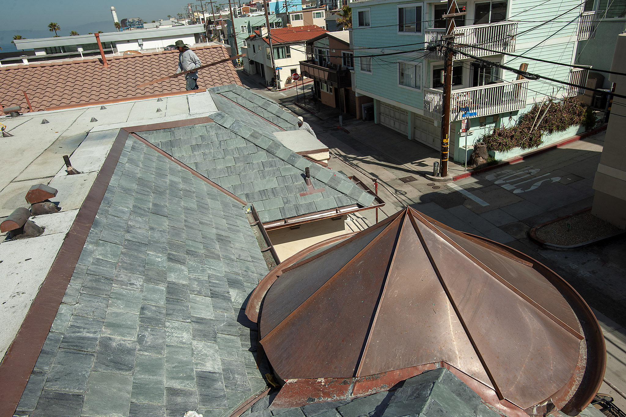 Roofers install coppper flashing on the Strand, Manhattan Beach, California